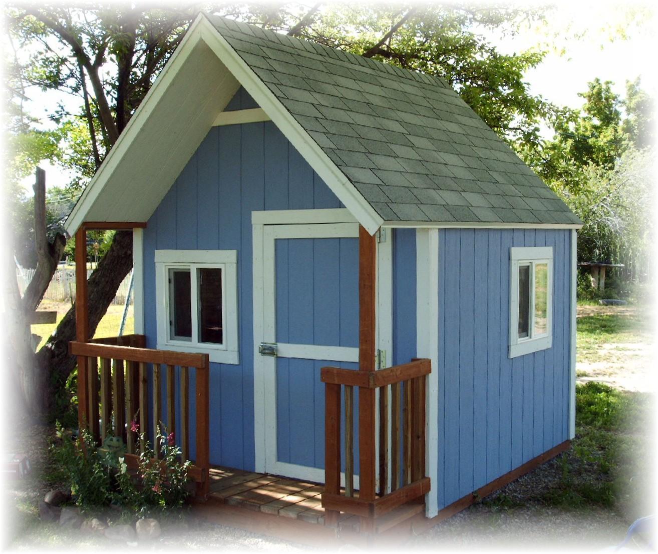 A light blue clubhouse playhouse that is 8 foot by 10 with porch and porch railing